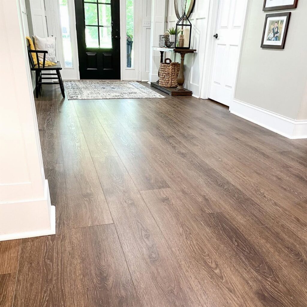Dark wood grain wide plank vinyl flooring in a bright, modern farmhouse style entryway.