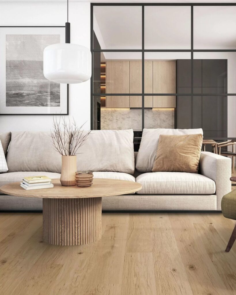 Light-toned wide plank hardwood floors in a modern living room with a beige sofa.