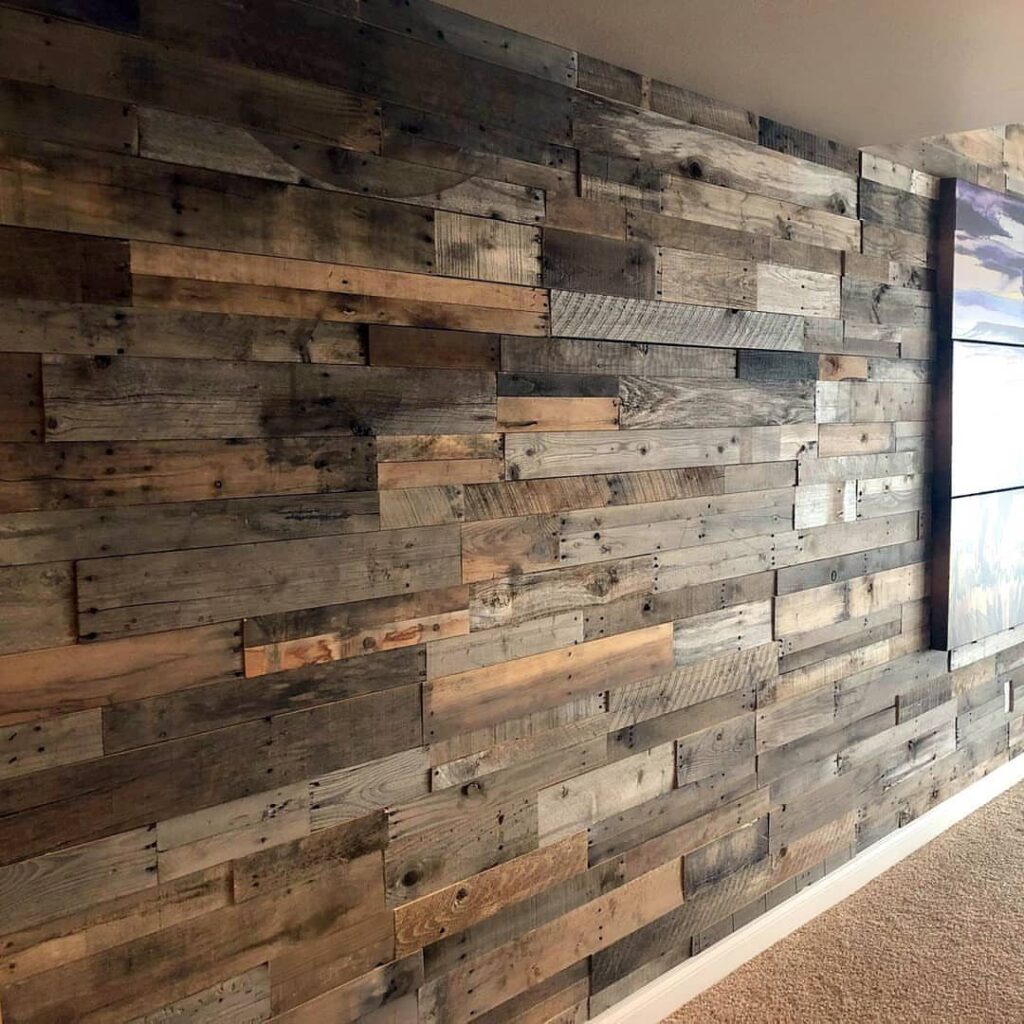 Distressed wood shiplap planks in various natural tones covering a large interior accent wall.